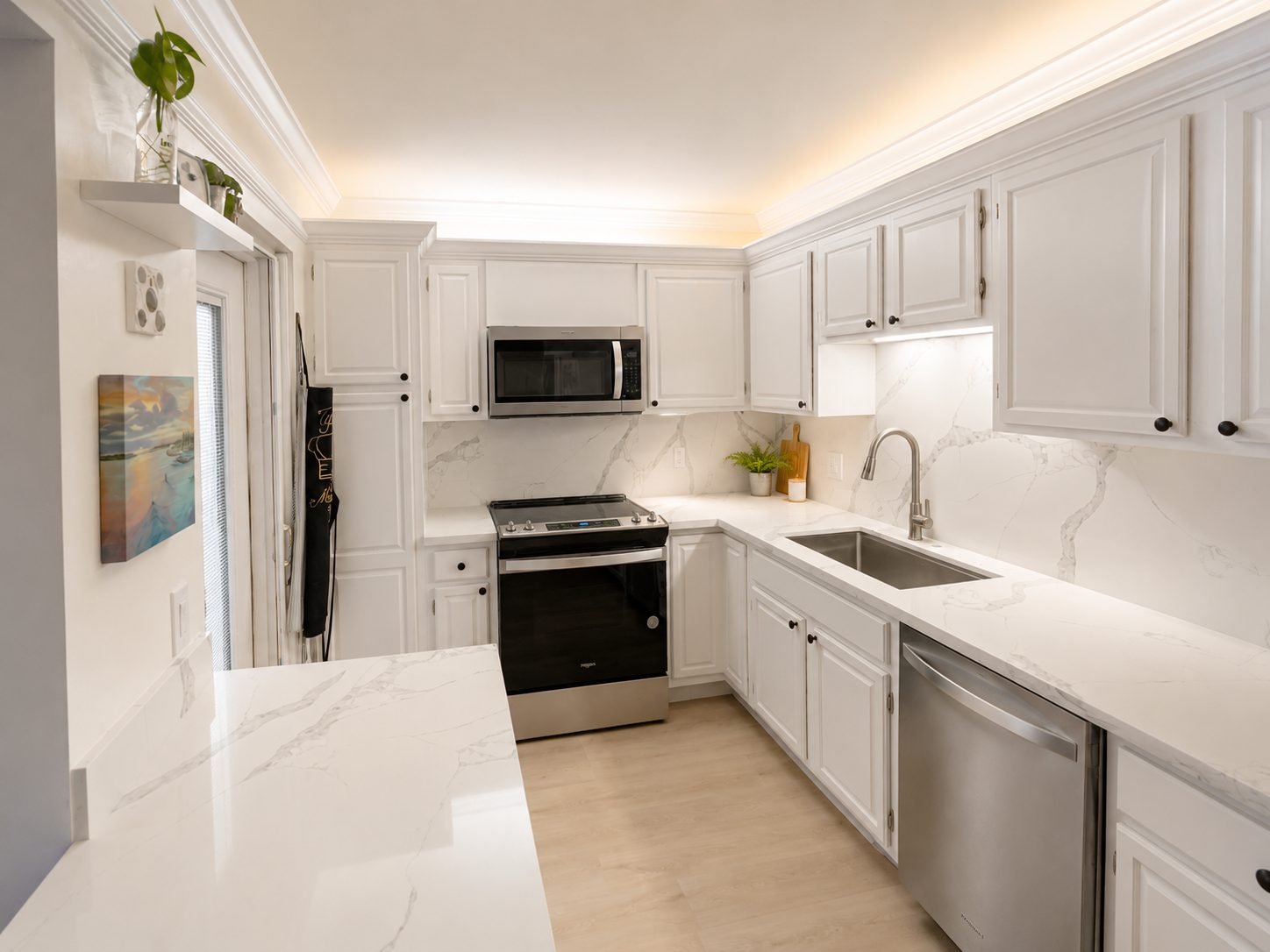 Modern white kitchen remodel with quartz countertops by About Kitchen & Bath
